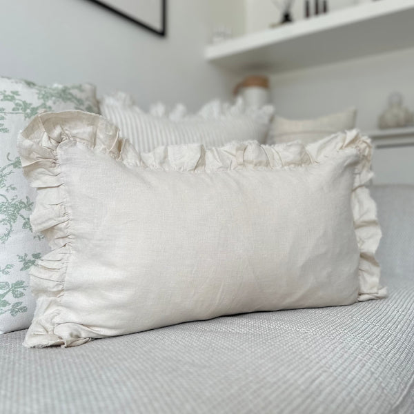 Rectangle Cream Ruffled Edge Linen Cushion 50x30cm sat on a cream sofa
